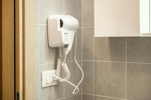 a phone is hanging on a wall in a bathroom at T12- Bilocale Free WiFi vicino a Bologna Fiera, Ravenna, Lugo Hospital Villa Maria in SantʼAgata sul Santerno