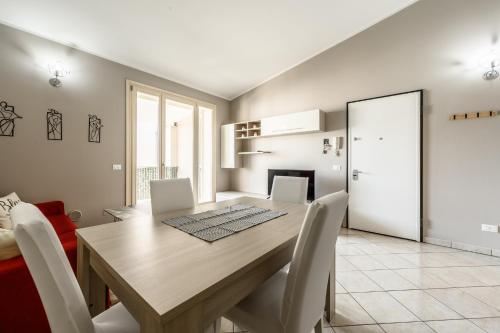 a dining room with a wooden table and white chairs at T12- Bilocale Free WiFi vicino a Bologna Fiera, Ravenna, Lugo Hospital Villa Maria in SantʼAgata sul Santerno