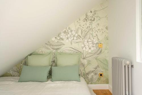 Un dormitorio con una cama con papel pintado floral. en Neptune, en Trouville-sur-Mer