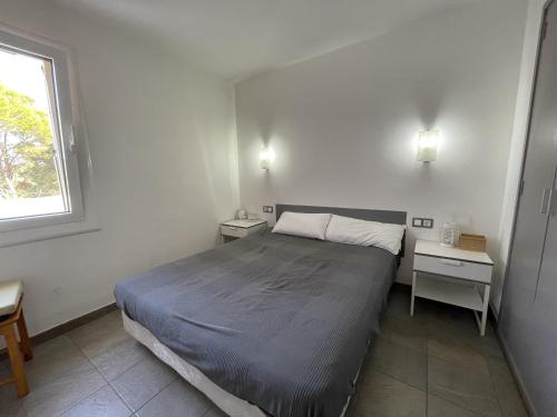 A bed or beds in a room at Acogedor apartamento con piscina comunitaria, cerca de la playa de Sa Tuna - ES-226-26