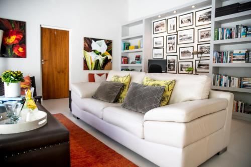 a living room with a white couch and bookshelves at Selkirk House in Hermanus