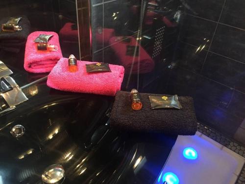 een badkamer met roze handdoeken en een zwarte wastafel bij Gîte 2 personnes pour une nuit en amoureux in Saint-Brevin-les-Pins