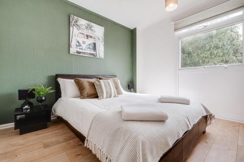 a bedroom with green walls and a large bed at Spacious and Pristine Home - Free Parking in Northampton