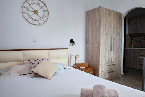 ein Schlafzimmer mit einem großen Bett und einer Uhr an der Wand in der Unterkunft Nikos apartment in Malia