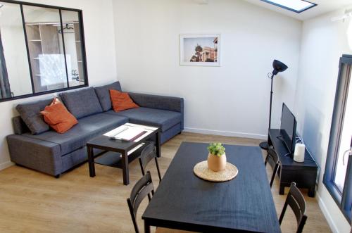 a living room with a couch and a table at Le St Apollinaire n°3 - Ma Cabotte in Meximieux