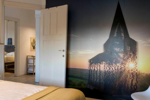 a bedroom with a mural of a building on the wall at VillaEnzo - ELEGANT HERENHUIS - 14P - 6SLPK - SAUNA - INFRAR CABINE - OFYR BBQ - 15MIN Maastricht in Zussen