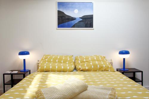 1 dormitorio con 1 cama amarilla y 2 lámparas azules en Le St Apollinaire n°3 - Ma Cabotte, en Meximieux