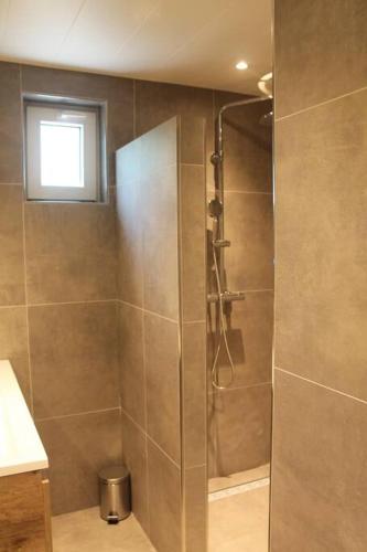 a shower with a glass door in a bathroom at Kellux vakantiewoning - Heleen in Mariënberg