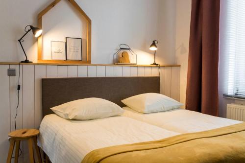 a bedroom with two beds and a mirror on the wall at VillaEnzo - ELEGANT HERENHUIS - 14P - 6SLPK - SAUNA - INFRAR CABINE - OFYR BBQ - 15MIN Maastricht in Zussen