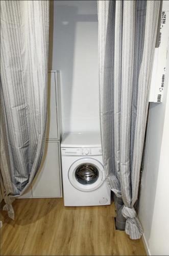 - un lave-linge dans une petite chambre avec des rideaux dans l'établissement Le St Apollinaire n°3 - Ma Cabotte, à Meximieux