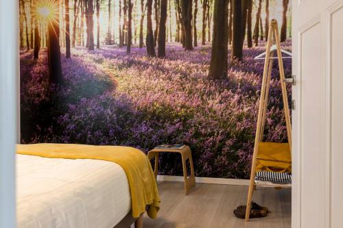 a bedroom with a mural of a forest with purple flowers at VillaEnzo - ELEGANT HERENHUIS - 14P - 6SLPK - SAUNA - INFRAR CABINE - OFYR BBQ - 15MIN Maastricht in Zussen