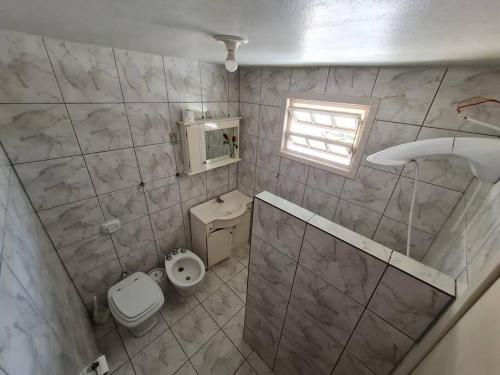 a small bathroom with a toilet and a sink at LINDO SOBRADO COM 7 QUARTOS NA BARRA DO ITAPOCU in Paraty