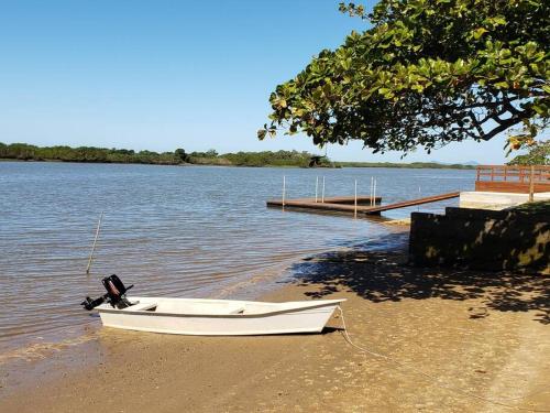 a boat sitting on the beach next to a dock at LINDO SOBRADO COM 7 QUARTOS NA BARRA DO ITAPOCU in Paraty