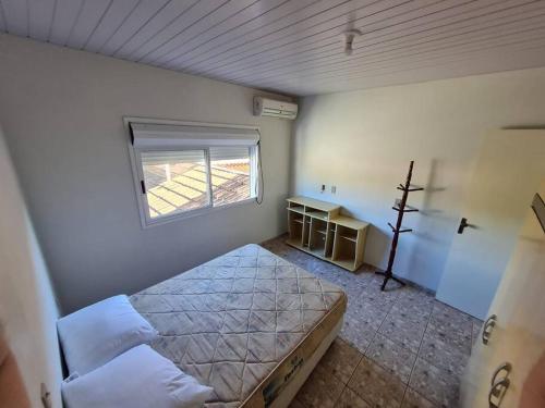 a bedroom with a bed and a window in it at LINDO SOBRADO COM 7 QUARTOS NA BARRA DO ITAPOCU in Paraty