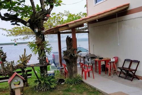 a patio of a house with a table and chairs at LINDO SOBRADO COM 7 QUARTOS NA BARRA DO ITAPOCU in Paraty