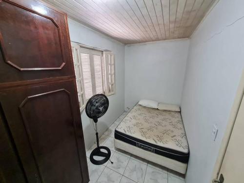 a small bedroom with a bed and a closet at LINDO SOBRADO COM 7 QUARTOS NA BARRA DO ITAPOCU in Paraty
