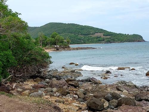 a group of rocks on the shore of a body of water at Villa L'Artist en bord de mer avec piscine privée in Sainte-Rose
