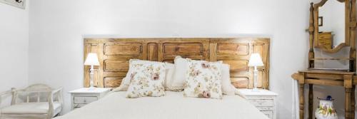 a bedroom with a large white bed with pillows at La casa de mis suegros in Candeleda