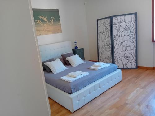 ein Schlafzimmer mit einem Bett mit zwei Handtüchern darauf in der Unterkunft Appartamento HAPPY DAYS con 1 posto auto privato in Lucca