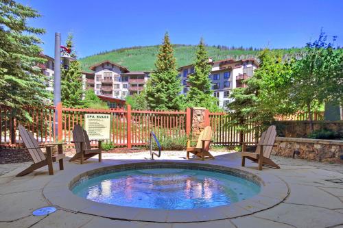 a patio with a pool with chairs and a table at Tx414 Taylors Crossing Condo in Copper Mountain