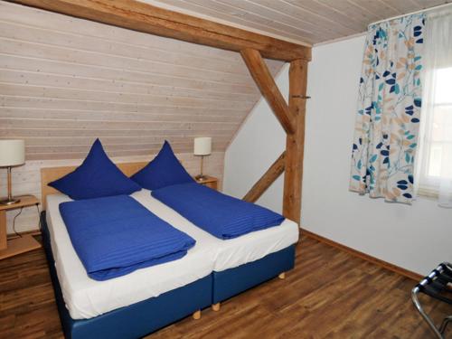 a bedroom with a bed with blue pillows at Kirschblüte in Colmberg