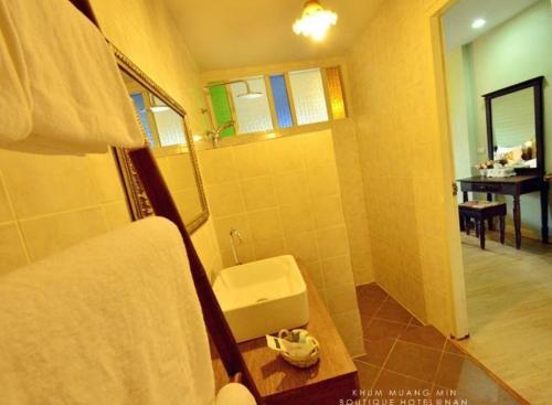 楠府的住宿－Khummuangmin Boutique Hotel Nan，一间带卫生间、水槽和镜子的浴室