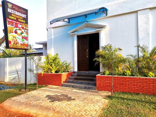 a building with a black door and stairs in front at Hotel NorthWay in Vavuniya