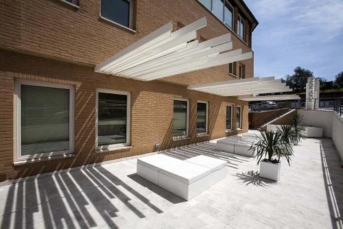 a patio with white furniture and a building at Porta Pispini Residence in Siena