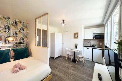 une chambre avec un lit et un bureau et une cuisine dans l'établissement La Suite Le studio ANANAS vue sur jardin proche plages, à Saint-Nazaire