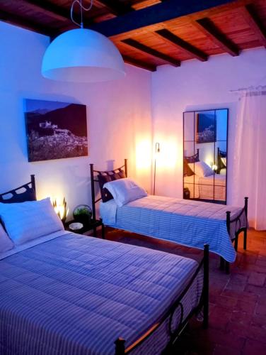 a bedroom with two beds and a mirror at Casa Vacanze Garibaldi in Spoleto