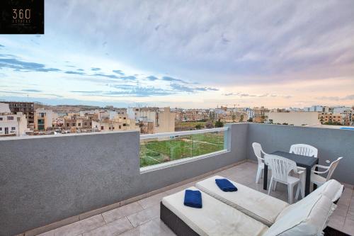 d'un balcon avec une table et des chaises et une vue. dans l'établissement Beautiful, 2BR Penthouse with large balcony + BBQ by 360 Estates, à Il-Gżira