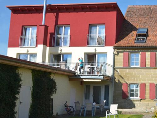 a red and white building with people on a balcony at Morgensonne in Colmberg