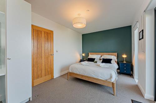 a bedroom with a bed and a blue wall at 2 Bed Ground Floor Apartment - 11 Plas in Pistyll