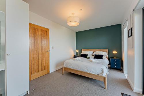 Un dormitorio con una cama y una pared azul. en 2 Bed Ground Floor Apartment - 11 Plas, en Pistyll