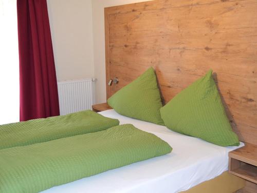 a bed with two green pillows on top of it at Marienkäfer in Colmberg
