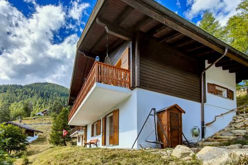 a house with a balcony on the side of it at Chalet Bijou in Blitzingen