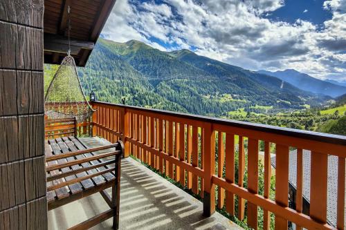 a balcony with a bench and a view of mountains at Chalet Bijou in Blitzingen