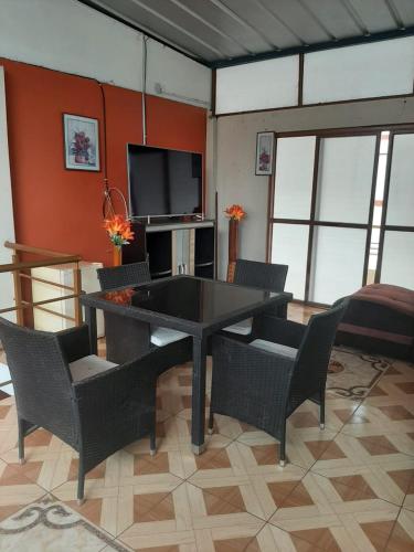 ein Wohnzimmer mit einem Tisch, Stühlen und einem TV in der Unterkunft CUARTO TINGALES in Tingo María