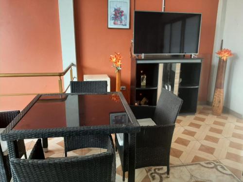 une salle à manger avec une table, des chaises et une télévision dans l'établissement CUARTO TINGALES, à Tingo María