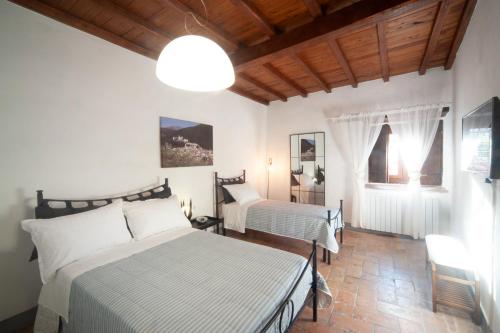 a bedroom with two beds and a chandelier at Casa Vacanze Garibaldi in Spoleto
