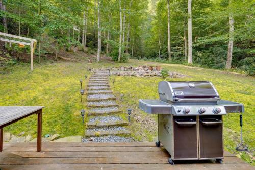 a grill and a picnic table in a yard at Cozy Log Cabin on 11 Acres 3 Mi to Cherokee Lake! in Bean Station