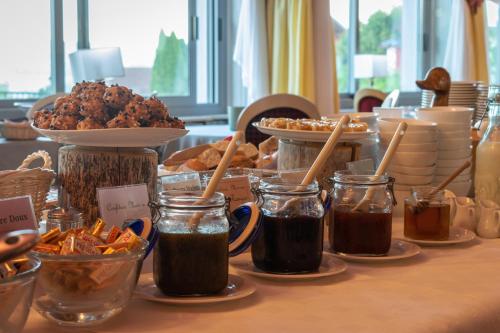 a table topped with different types of food in jars at Hôtel de la Poste in Malbuisson