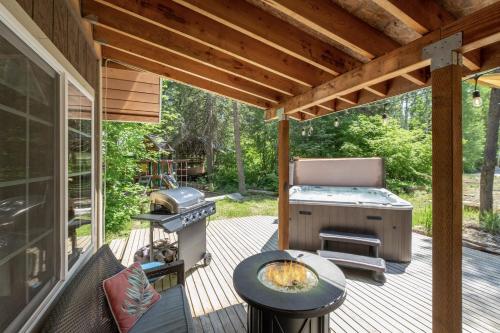 a screened in porch with a grill and a barbecue at Lil Bigfoot Chalet by NW Comfy Cabins in Leavenworth