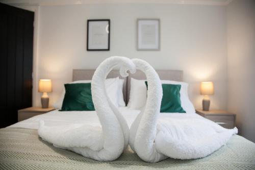two swans made out of towels sitting on a bed at 8 Karslake Road in Wallasey