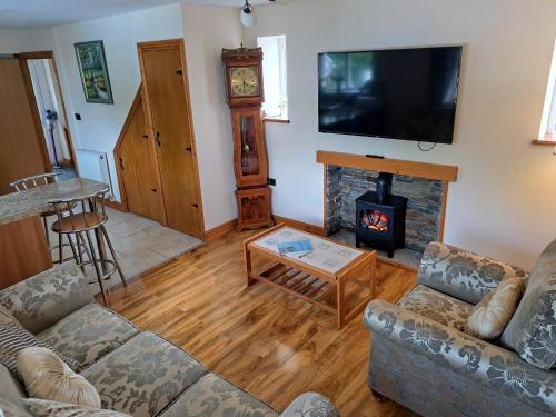 a living room with a couch and a fireplace at Rose Cottage Trecynon Traditional 2 bed cottage Zip World Beacons Bike in Aberdare