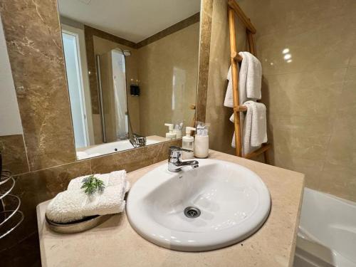 a bathroom with a white sink and a bath tub at Saltwater Apartment in Portimão