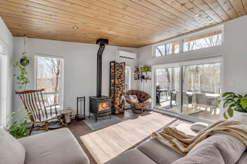 a living room with a couch and a fireplace at Le Gaïa - Chalet en nature in Quebec City