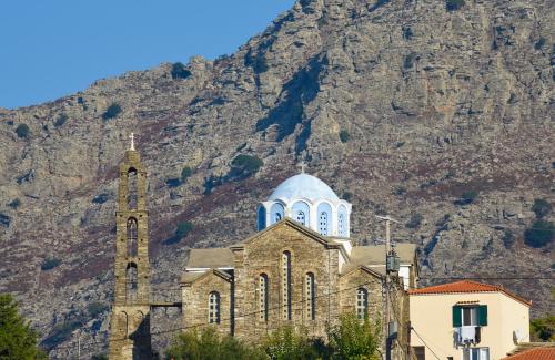 a church with a mountain in the background at Endless green 1 Arethousa Ikaria in Arethousa