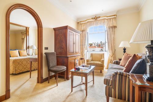 a living room with a couch and a bedroom at Palácio Estoril Hotel, Golf & Wellness in Estoril