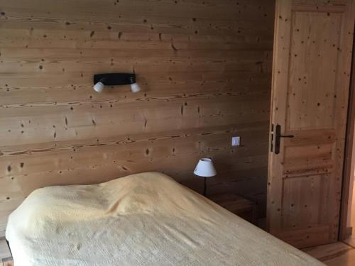 a bedroom with a bed and a wooden wall at Appartement Les Gets, 4 pièces, 6 personnes - FR-1-671-99 in Les Gets